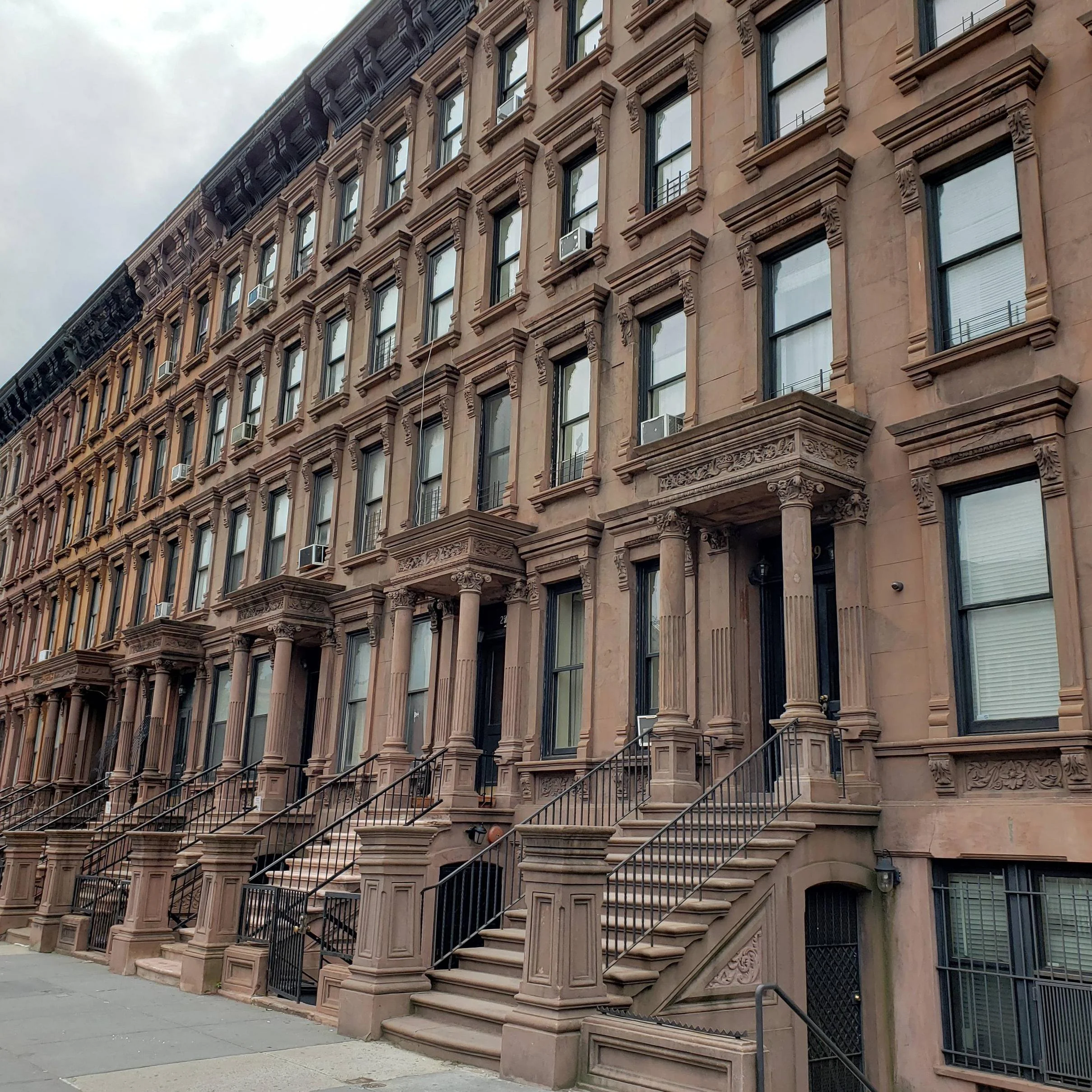 A brownstone in neglected condition, showing signs of deterioration over the years.