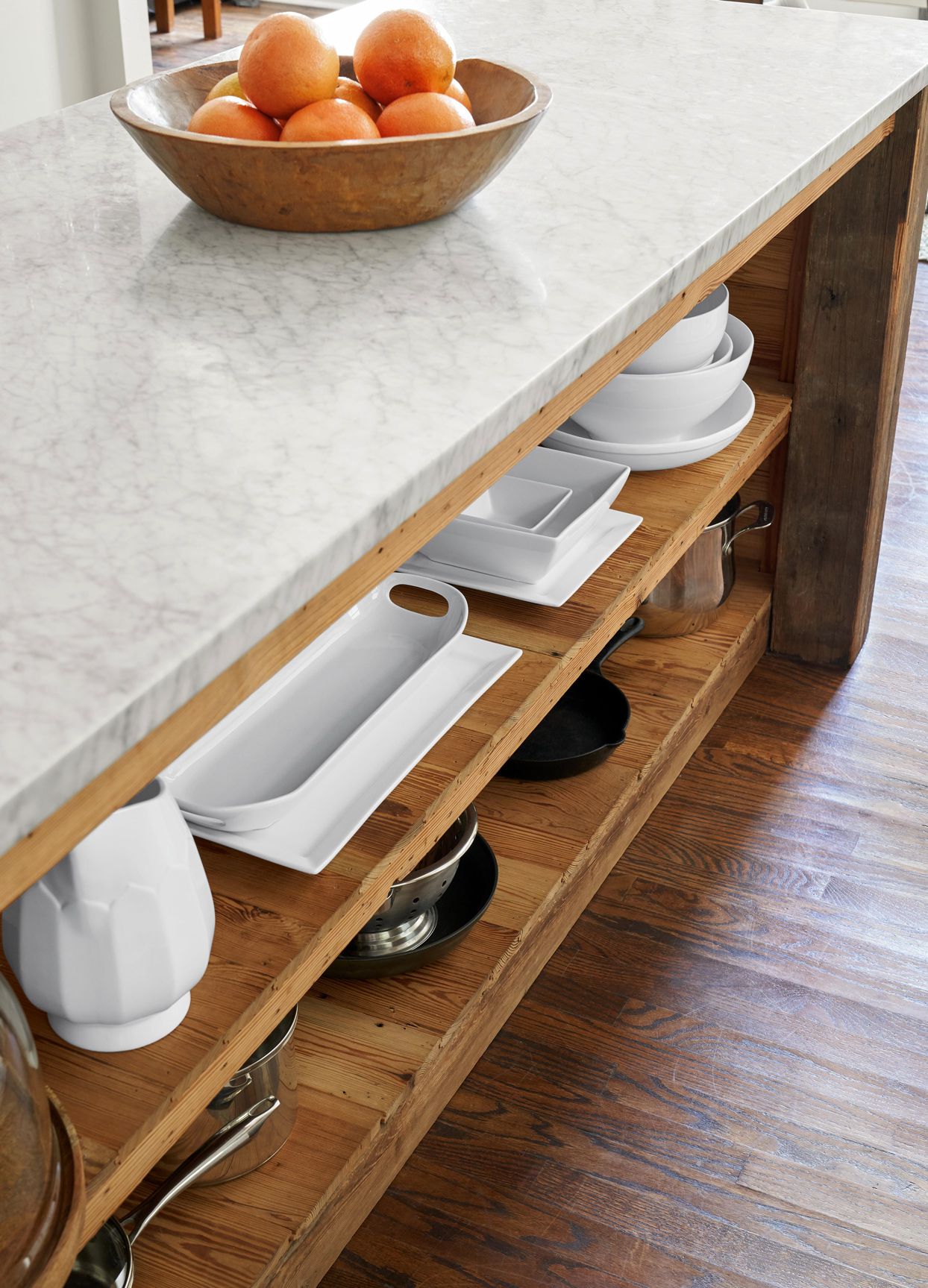 Innovative storage within a high-end kitchen island, featuring deep drawers and pull-out shelves.