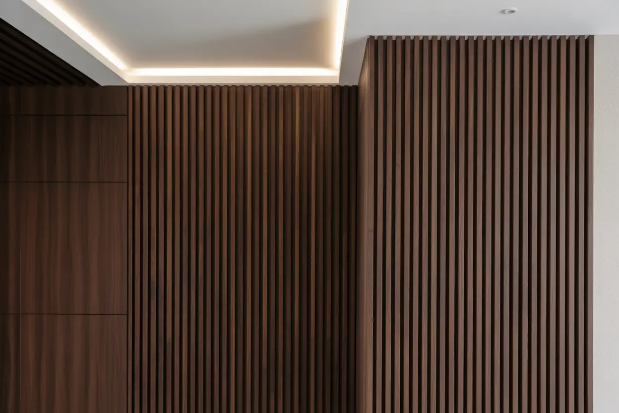 Vertical walnut wood slat feature wall with integrated backlighting in a luxury Manhattan bedroom.