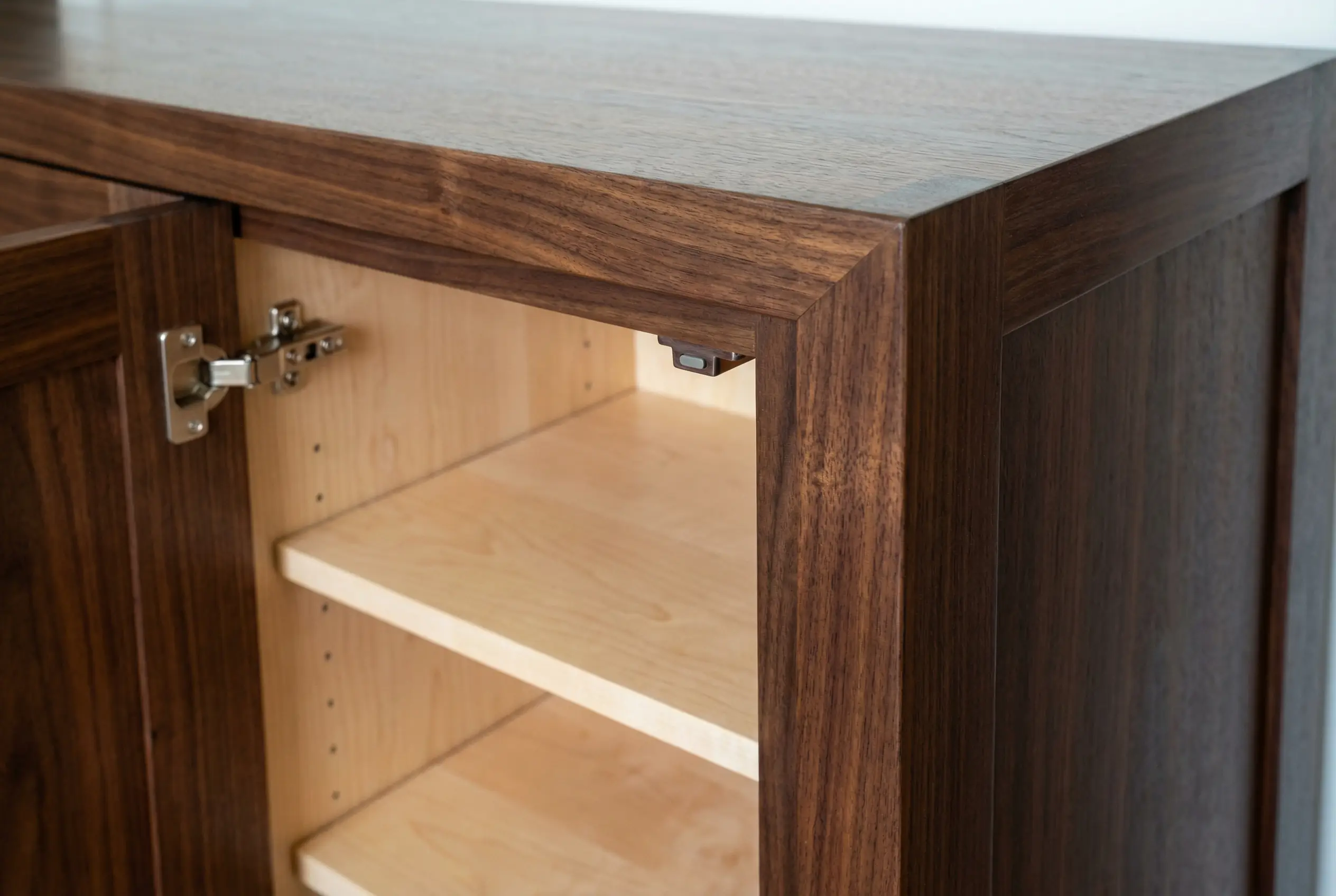 Close-up of seamless miter joint and grain matching on dark walnut cabinet corner