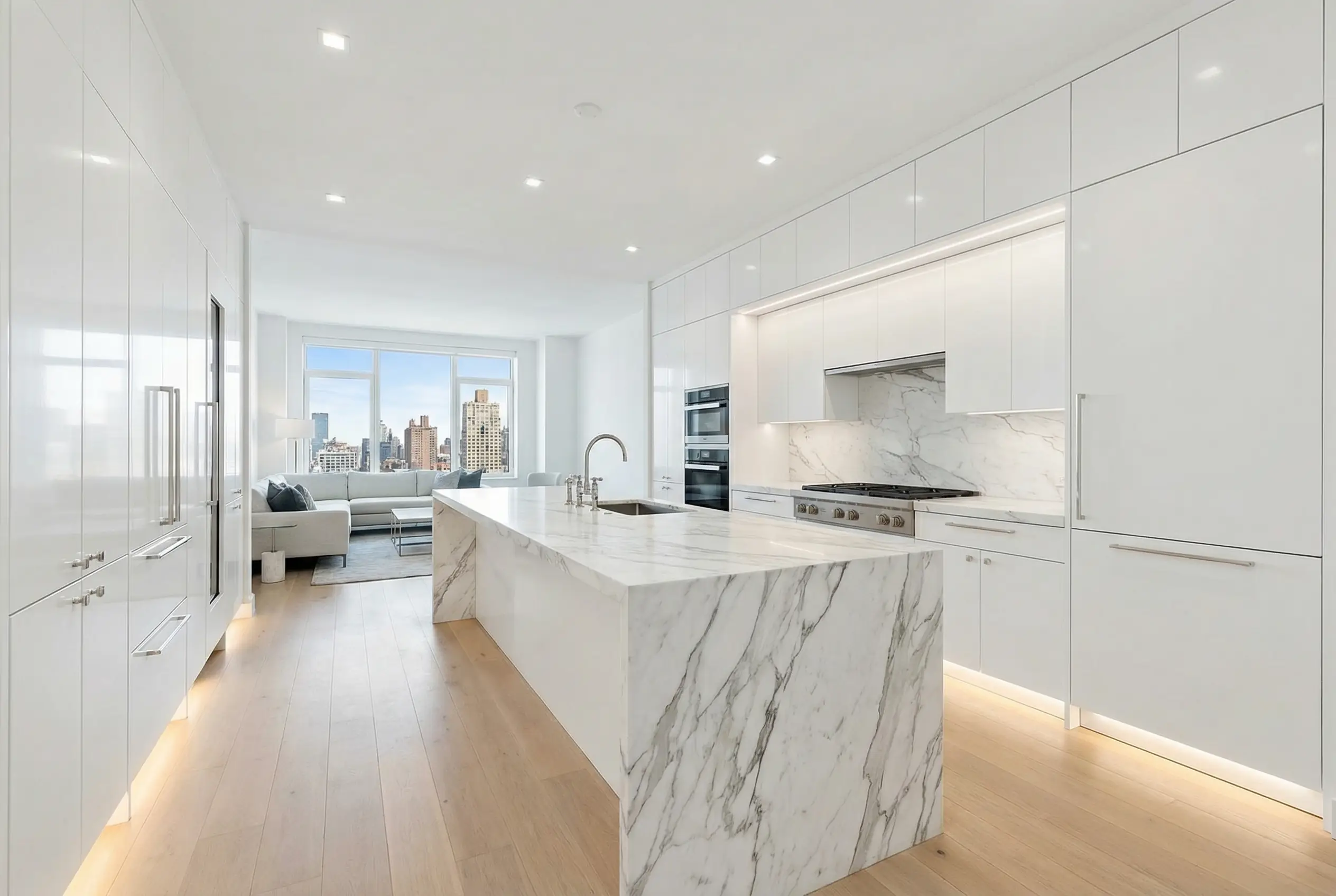 Luxury Manhattan co-op kitchen renovation with marble waterfall island and white custom cabinetry after board approval