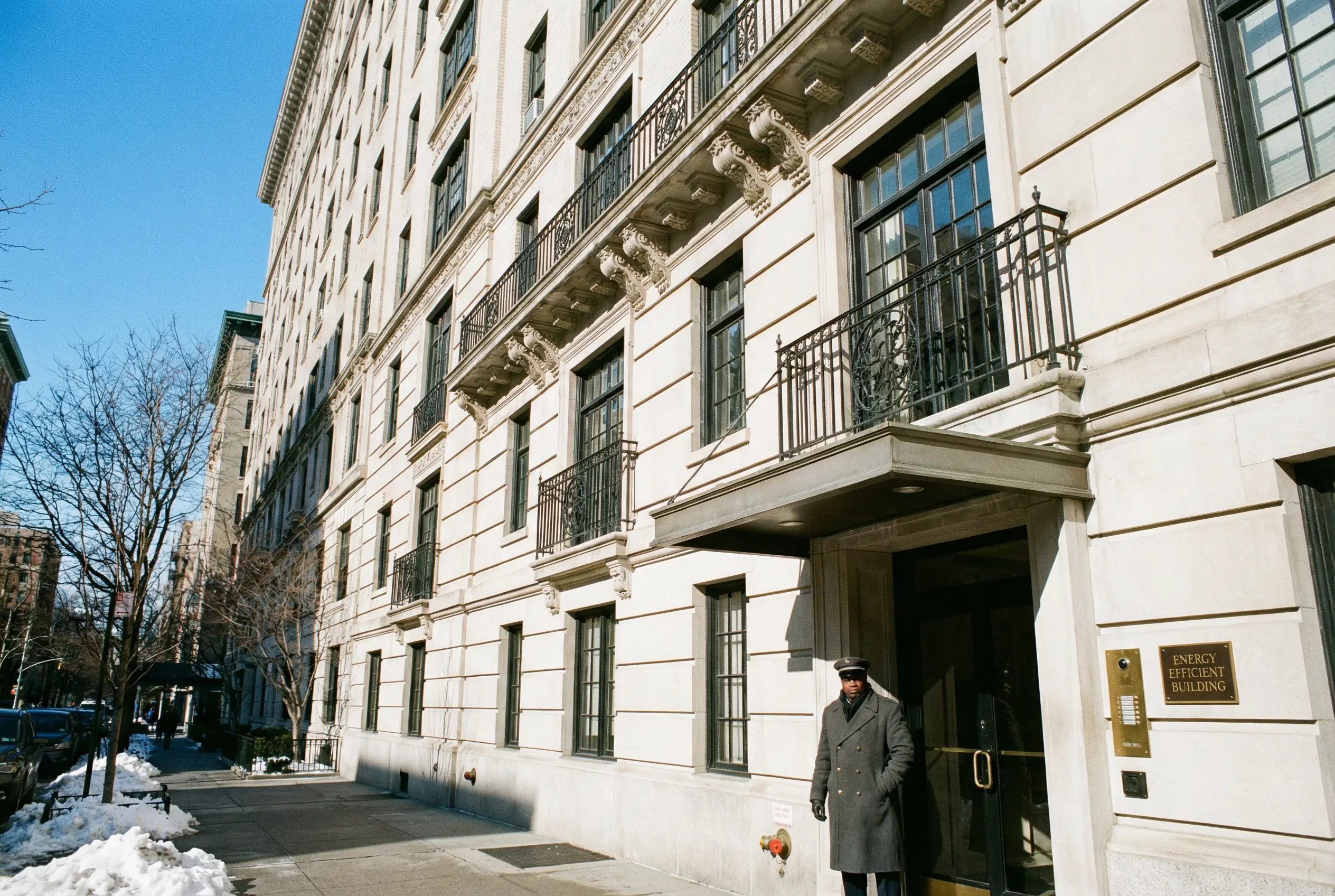 Manhattan pre-war limestone apartment building exterior with energy efficiency compliance placard NYC Local Law 97